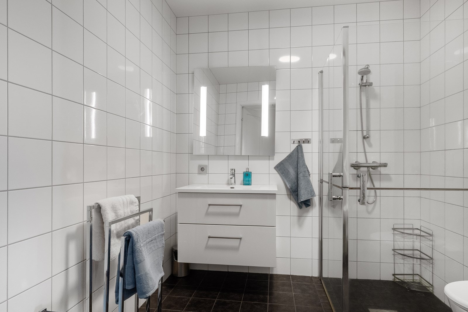 Badet i 2. etasje er innredet med servantskap med servant, dusjhjørne, veggmontert toalett og opplegg for vaskemaskin. Galleribilde