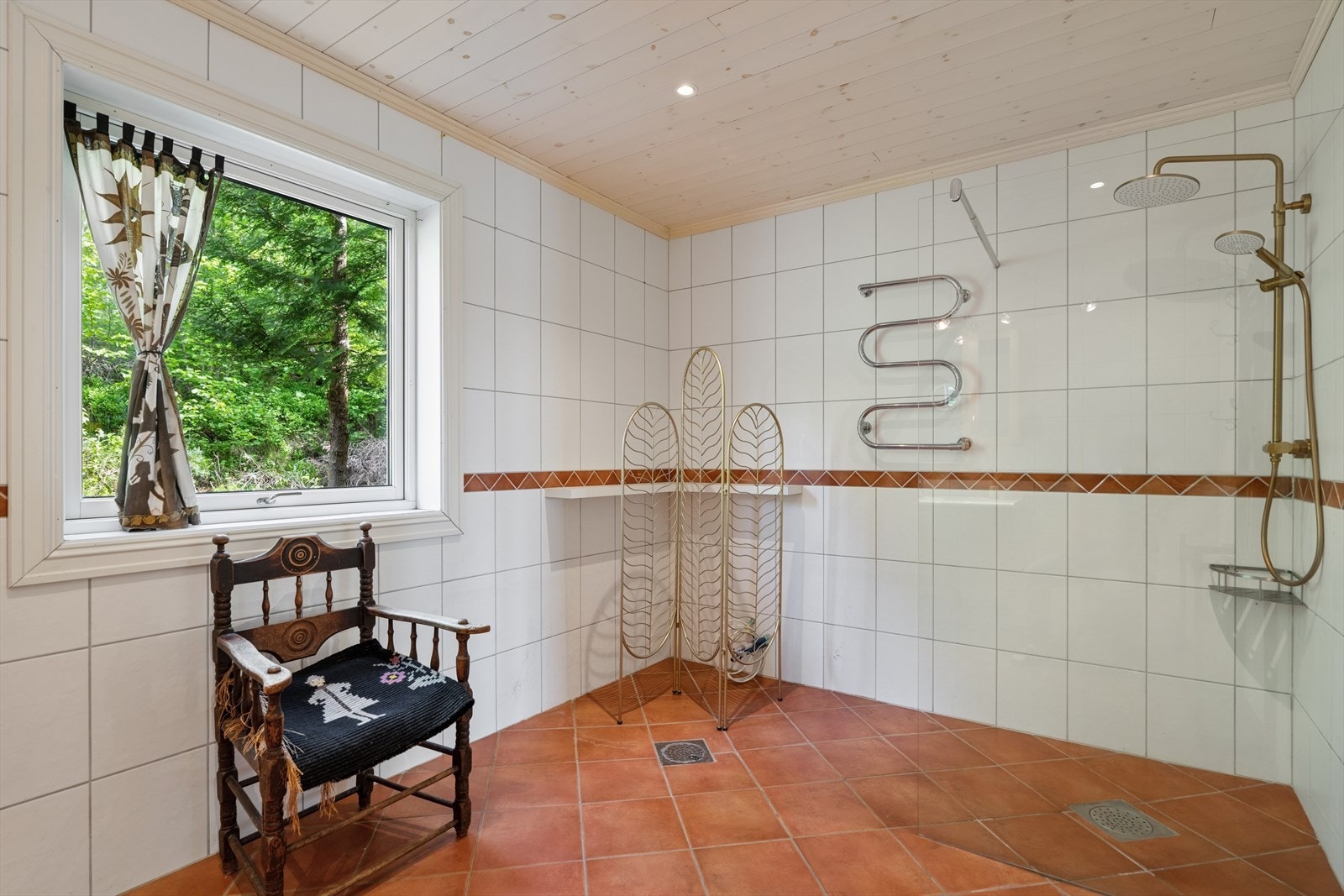 Badet har innredning med heltre fronter av bjørk og en åpen dusjløsning. Galleribilde