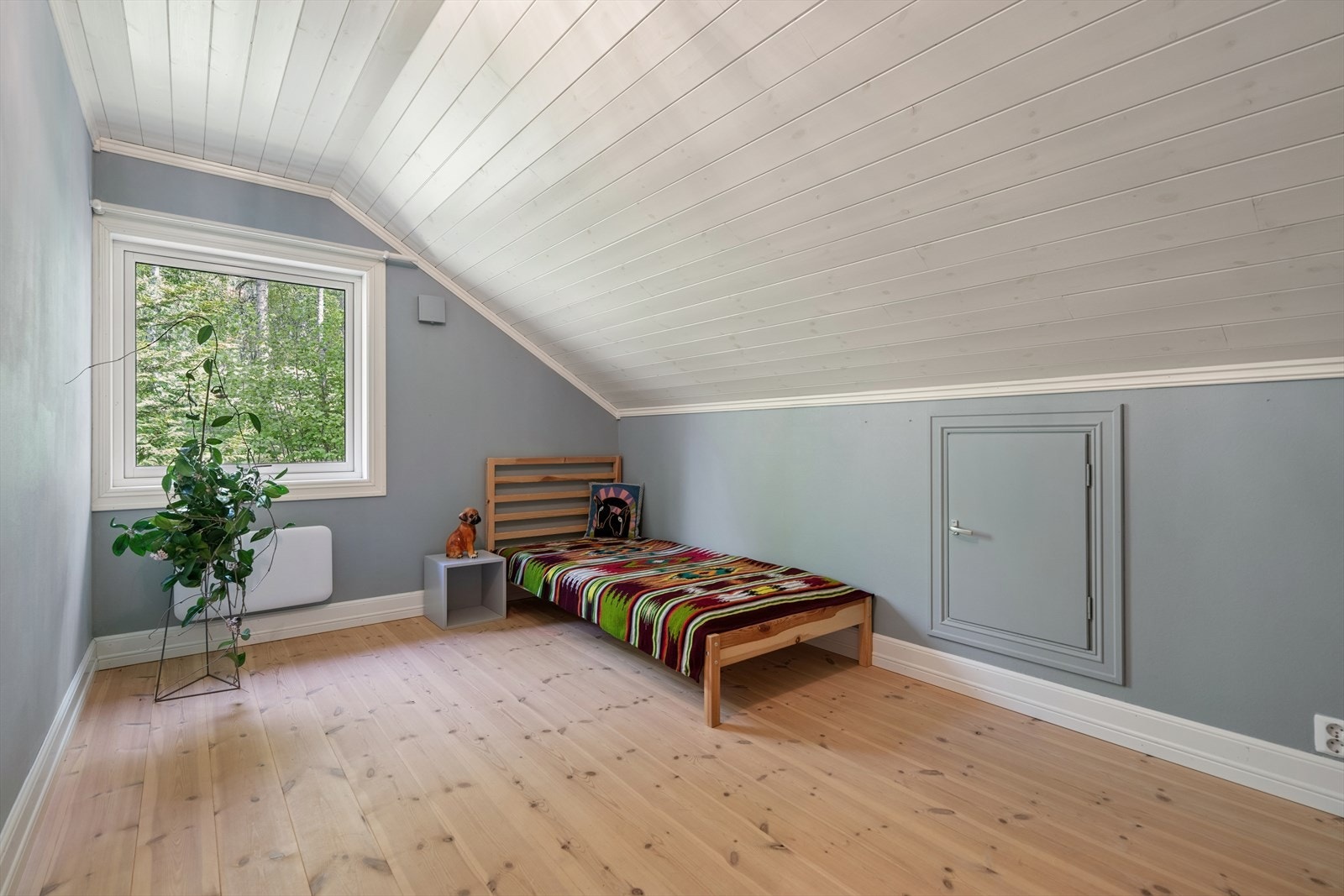 Soverom i loftsetasjen med malt panel og furugulv. Galleribilde