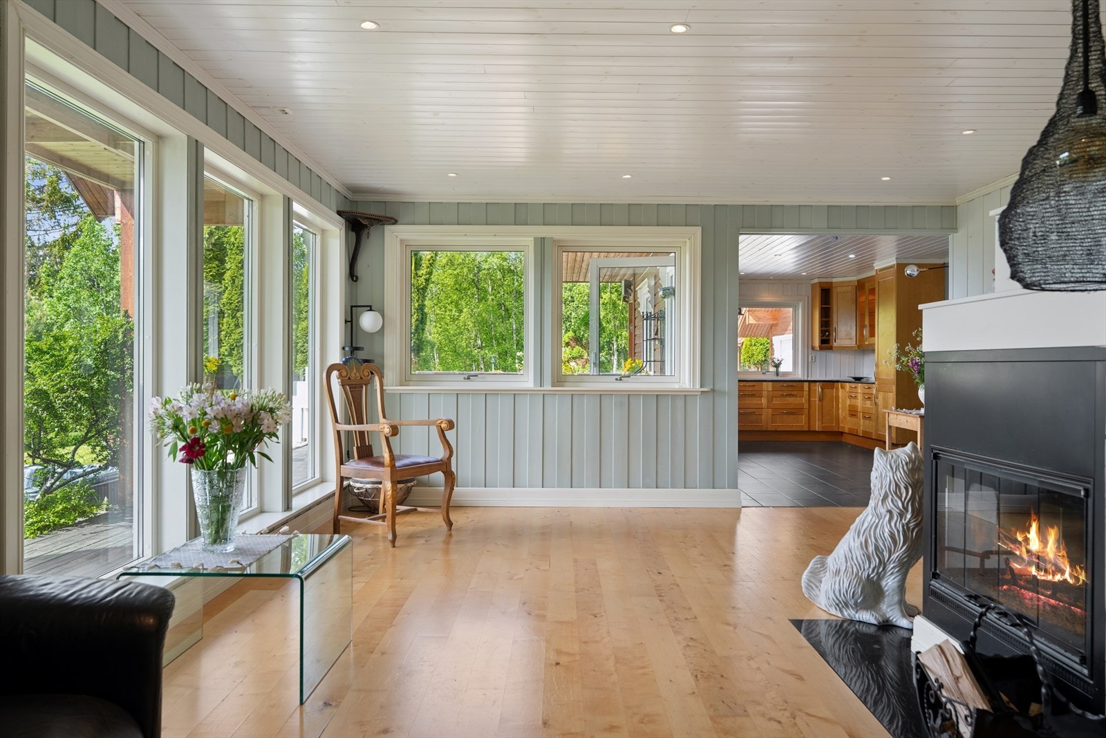 Stuen har parkett på gulv, vannbåren gulvvarme og en sentralt plassert peis. Galleribilde