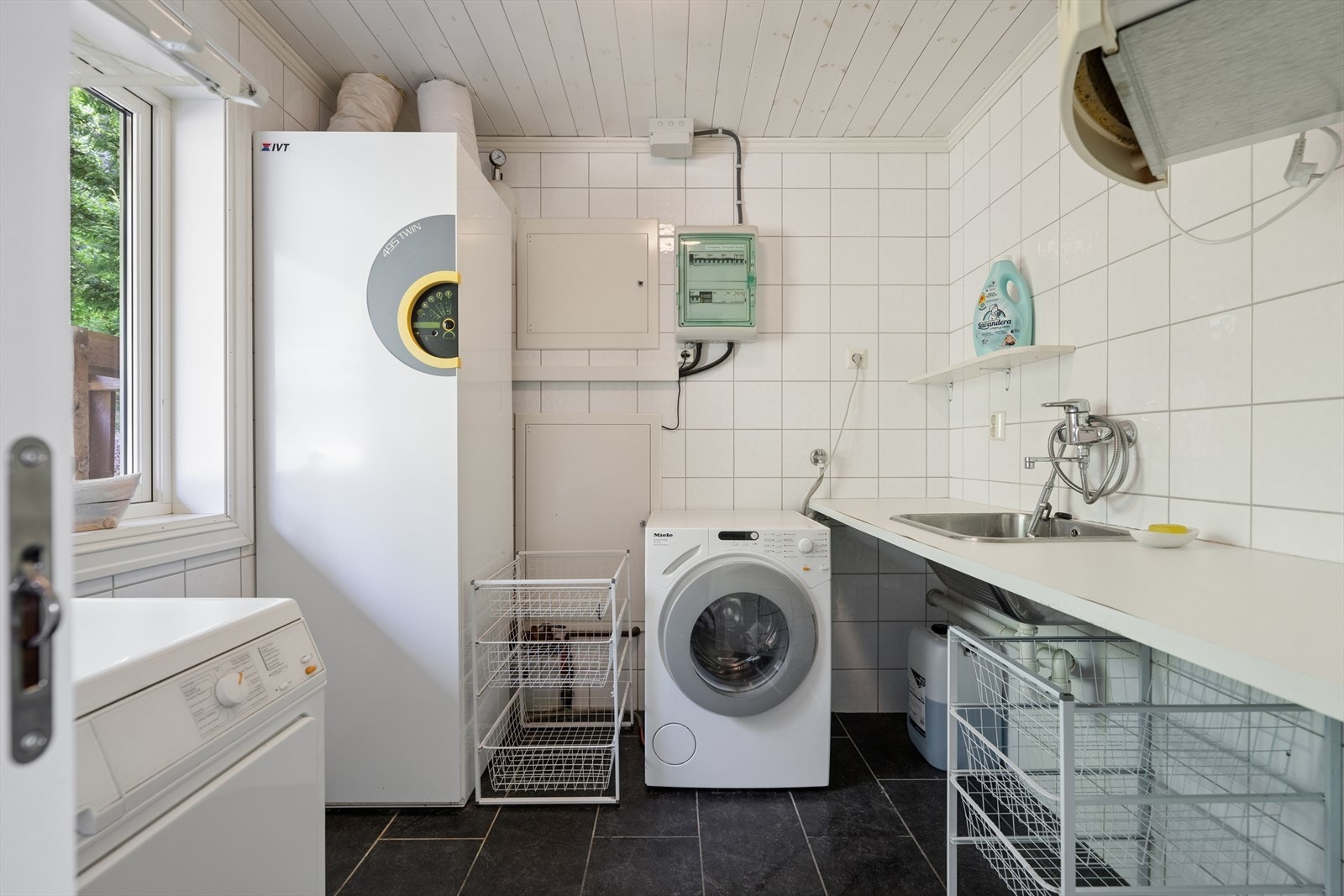 Separat vaskerom med flislagt gulv, gulvvarme og opplegg for vaskemaskin. Her står også varmepumpen IVT 495. Galleribilde