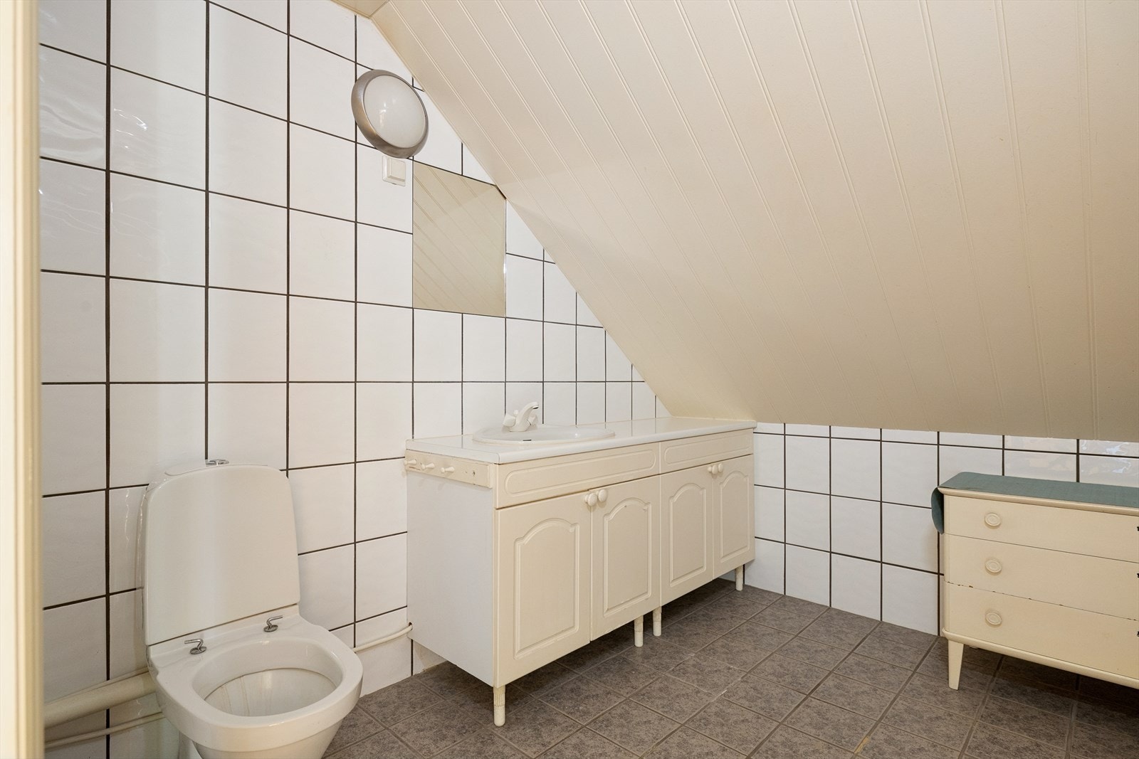 Badet på loftet er fra byggeåret og har flislagt gulv og vegger. Galleribilde
