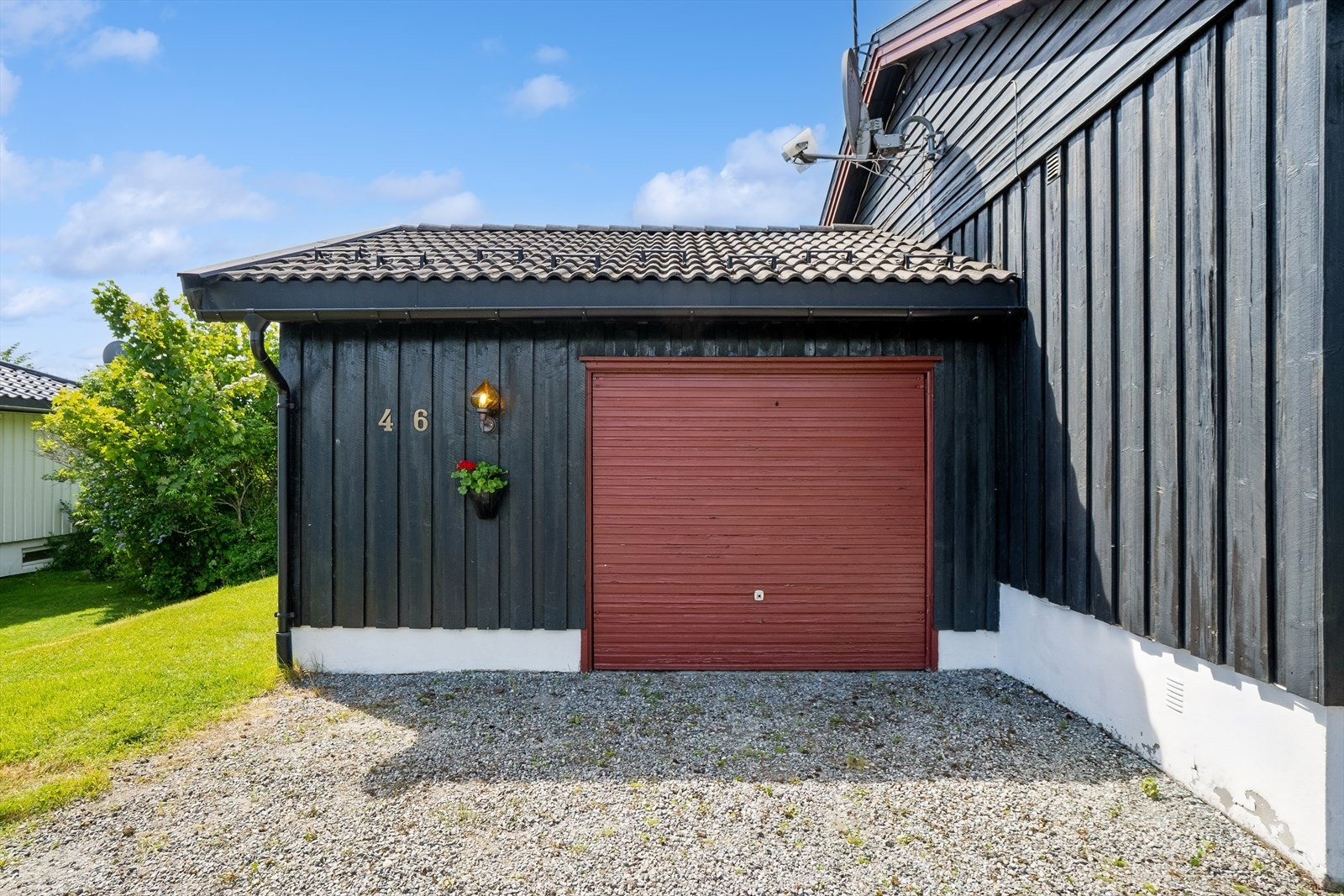 Garasjen er bygget inntil huset og inkluderer en praktisk utvendig bod på 7 m². Galleribilde