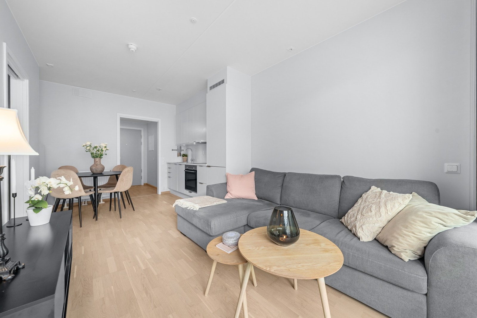Lyst og moderne stue/kjøkken med parkett på gulv, god plass til både sofagruppe og spisebord, samt radiatorer tilknyttet felles varmeanlegg. Galleribilde