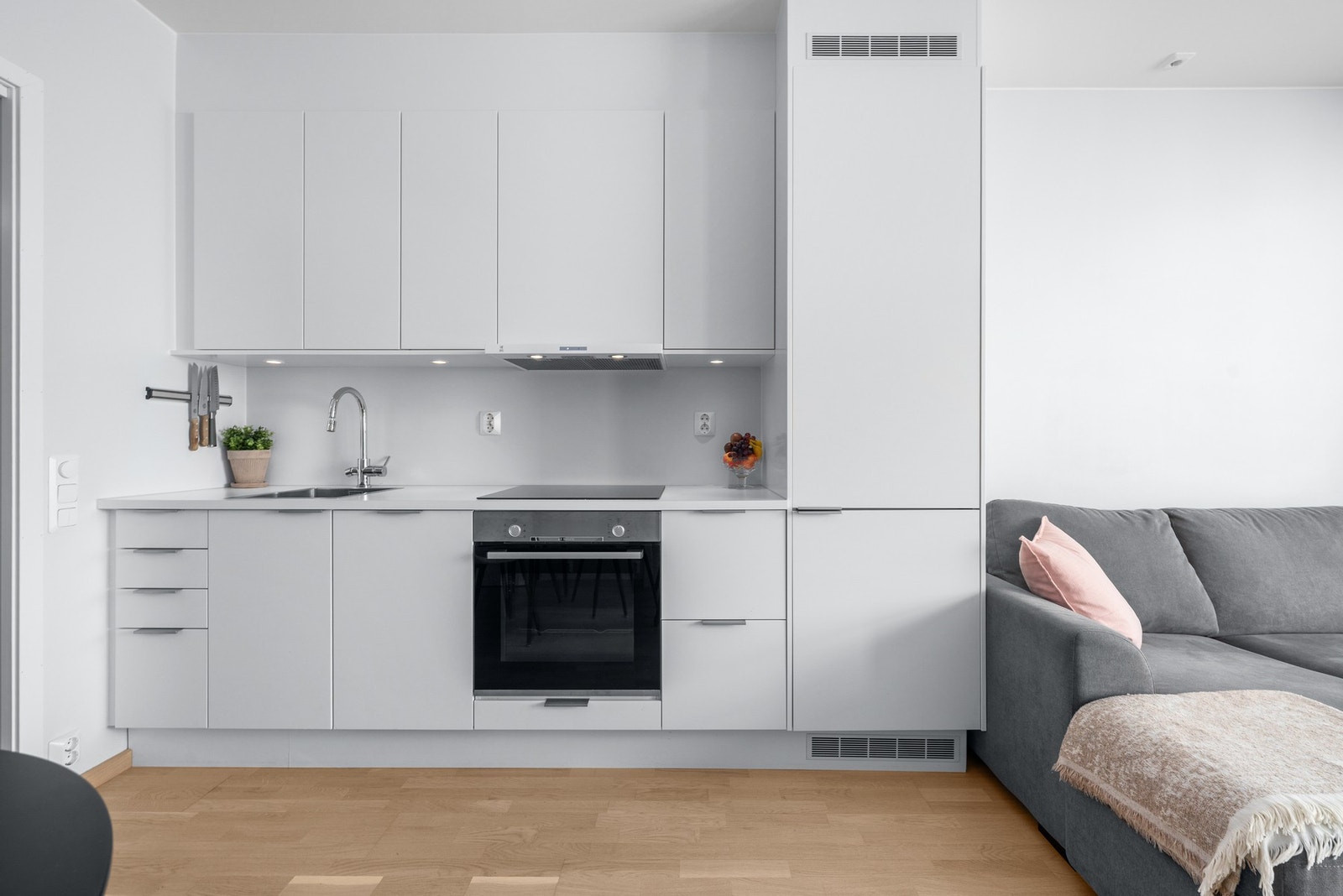 Stilren kjøkkeninnredning fra 2021 med glatte fronter, laminat benkeplate og integrerte hvitevarer. Galleribilde