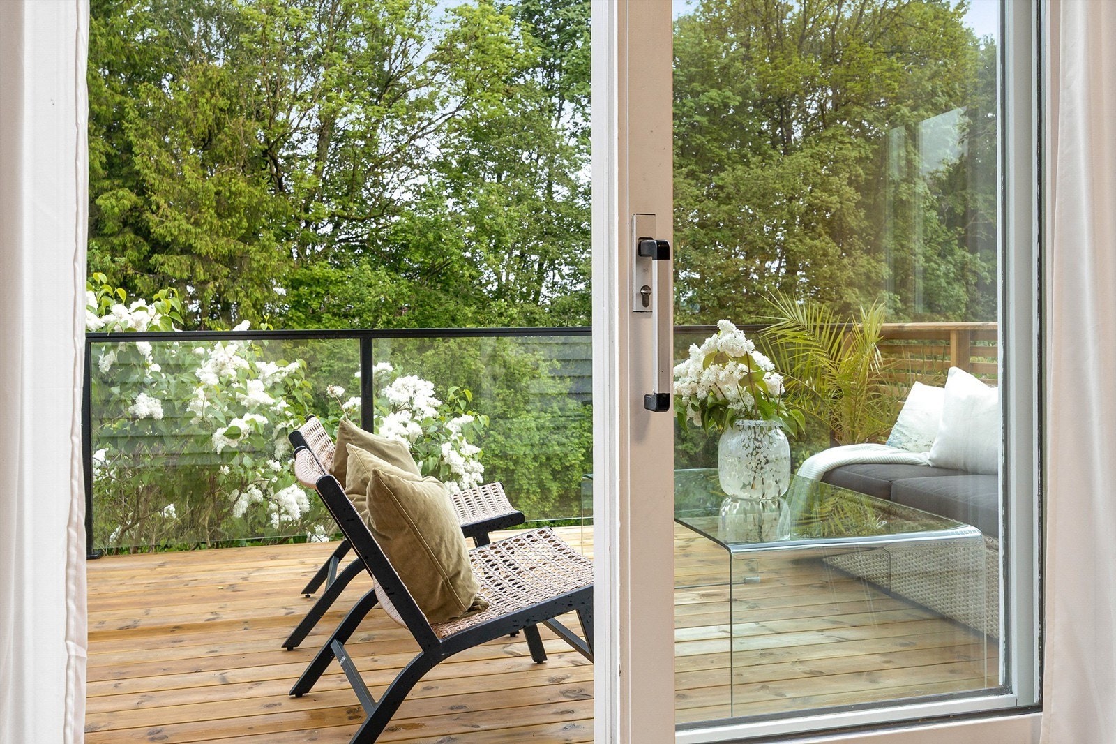 Verandaen i første etasje har rekkverk i tre, glass og metall. Galleribilde