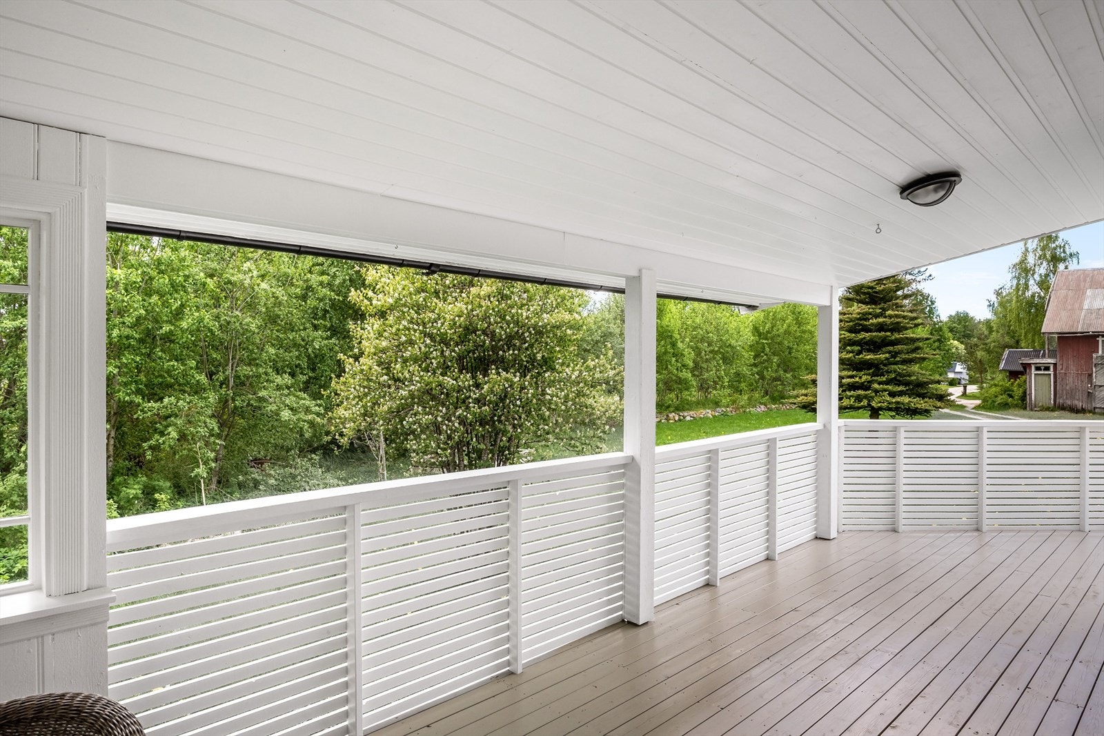Terrassen har terrassebord på gulv og rekkverk med liggende treverk. Galleribilde