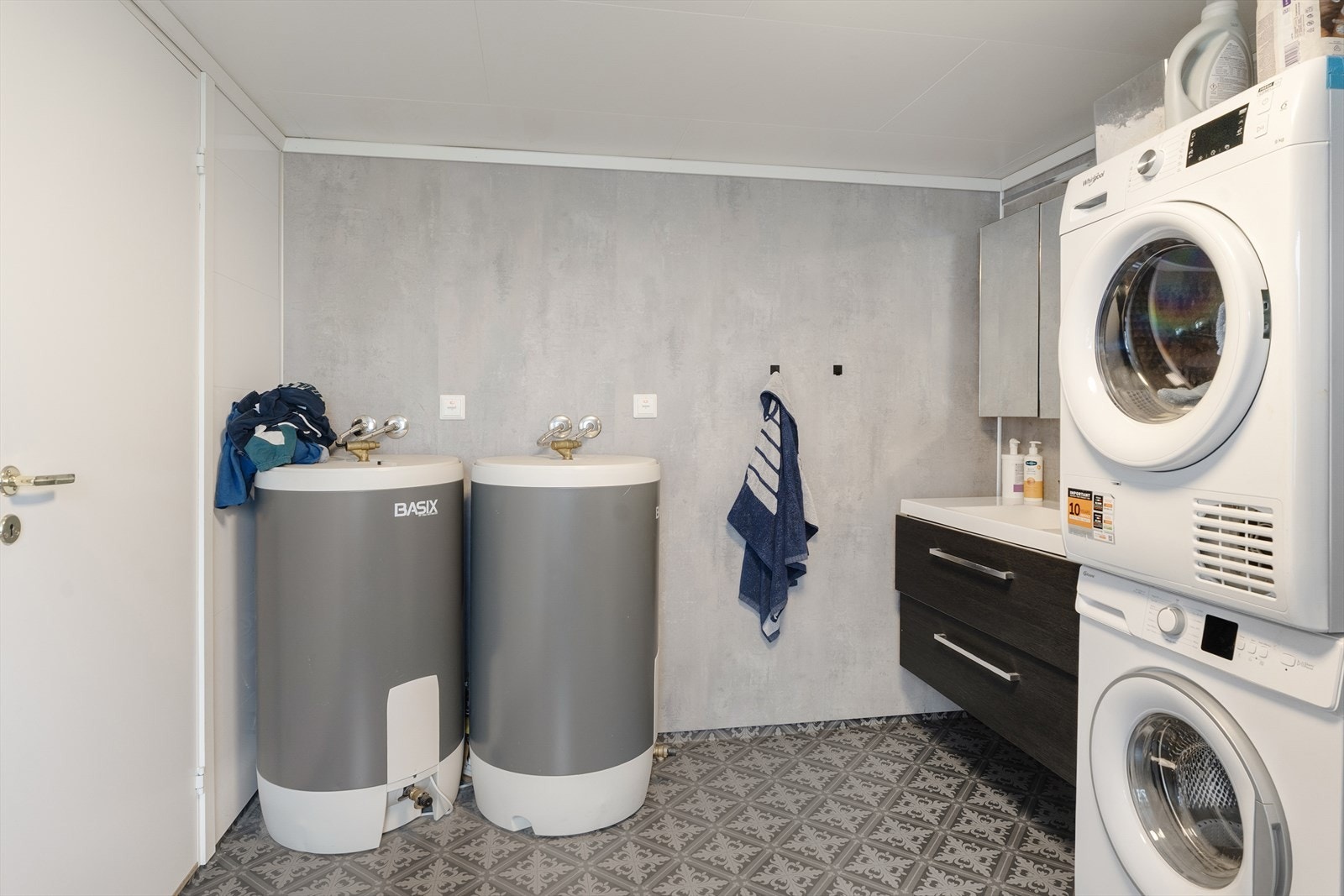 Badet i underetasjen har vinylbelegg med elektriske varmekabler, baderomsplater på vegger og er innredet med dusjkabinett, toalett, servantinnredning og opplegg for vaskemaskin. Galleribilde