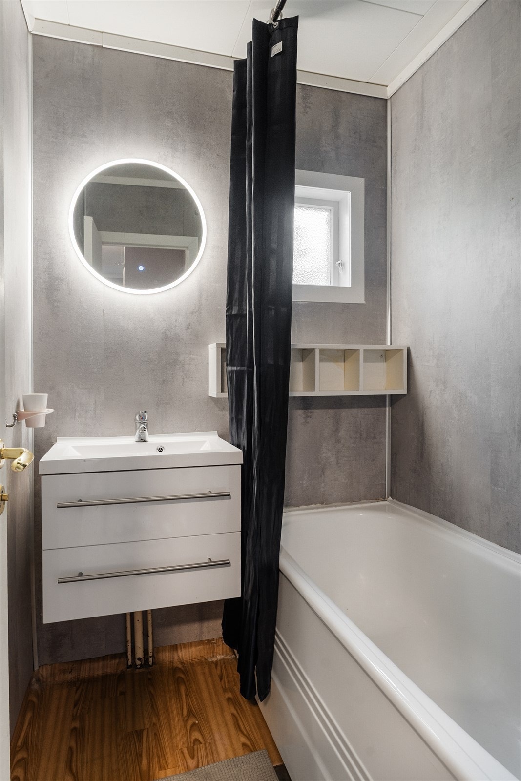 Badet i 1. etasje har belegg på gulv, baderomsplater på vegger og er utstyrt med badekar og servantinnredning. Galleribilde
