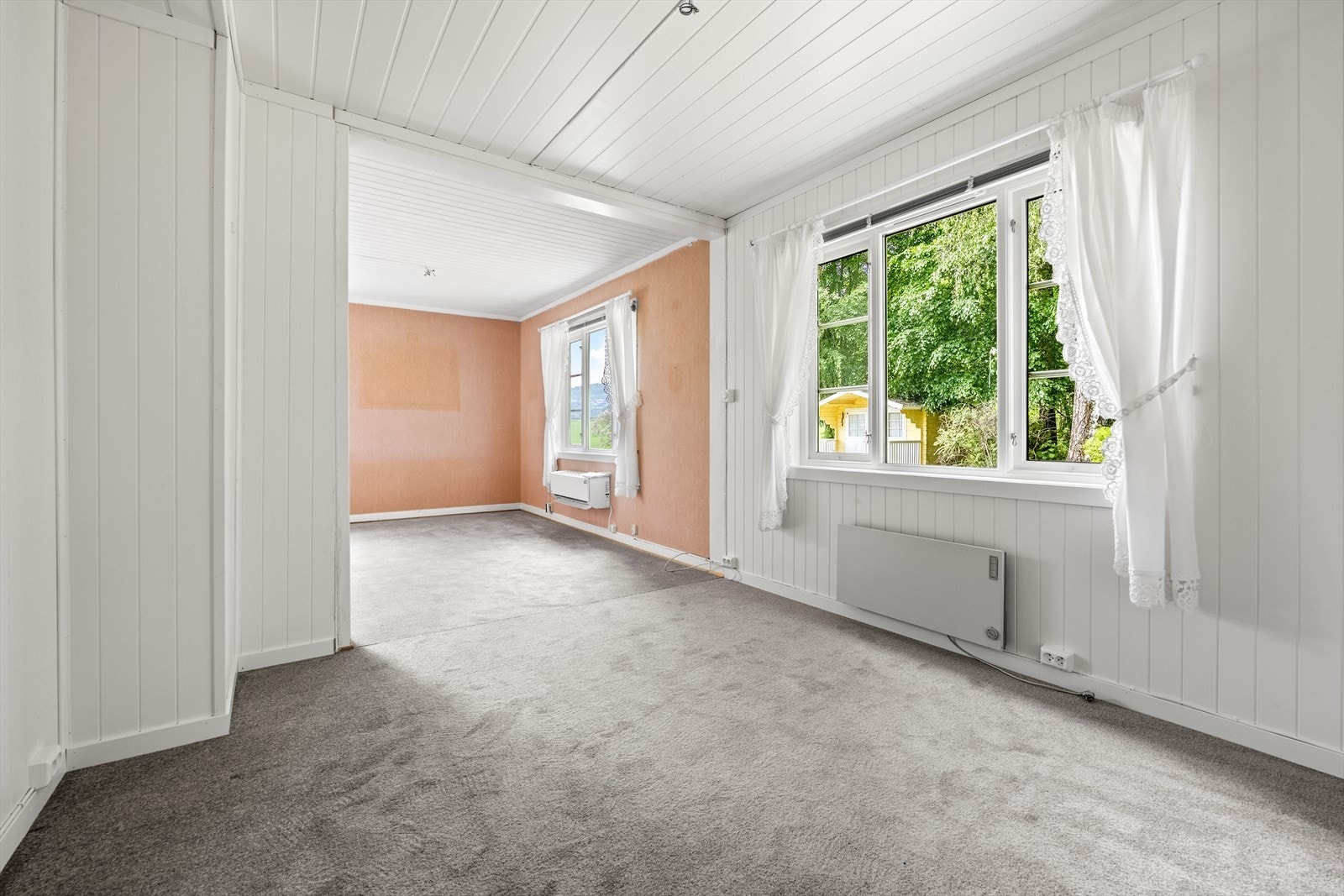 Stuen har en kombinasjon av overflater med trepanel, tapet og malte himlingsplater. Galleribilde