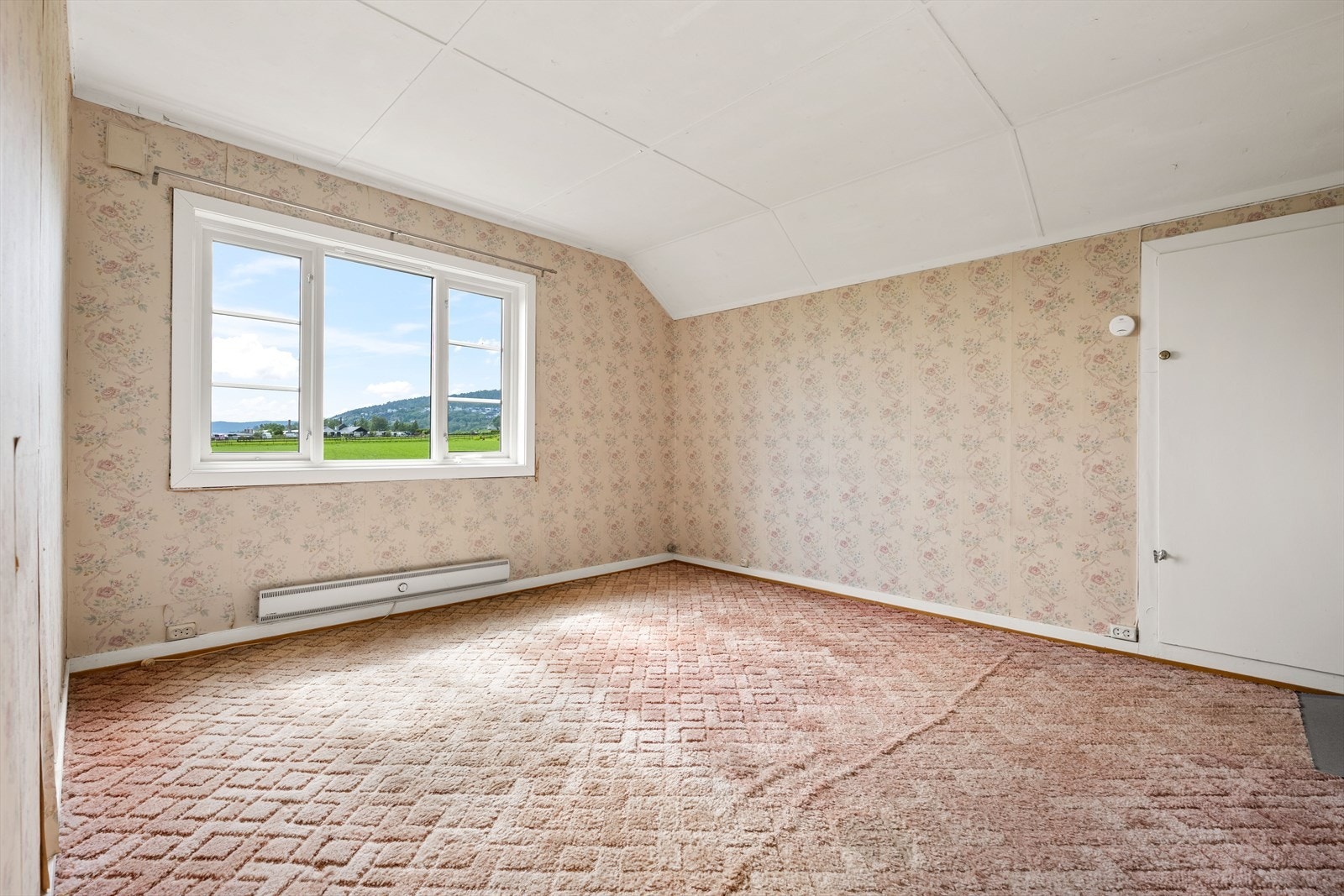 Rommet har teppe på gulvet og tapetserte vegger. Galleribilde
