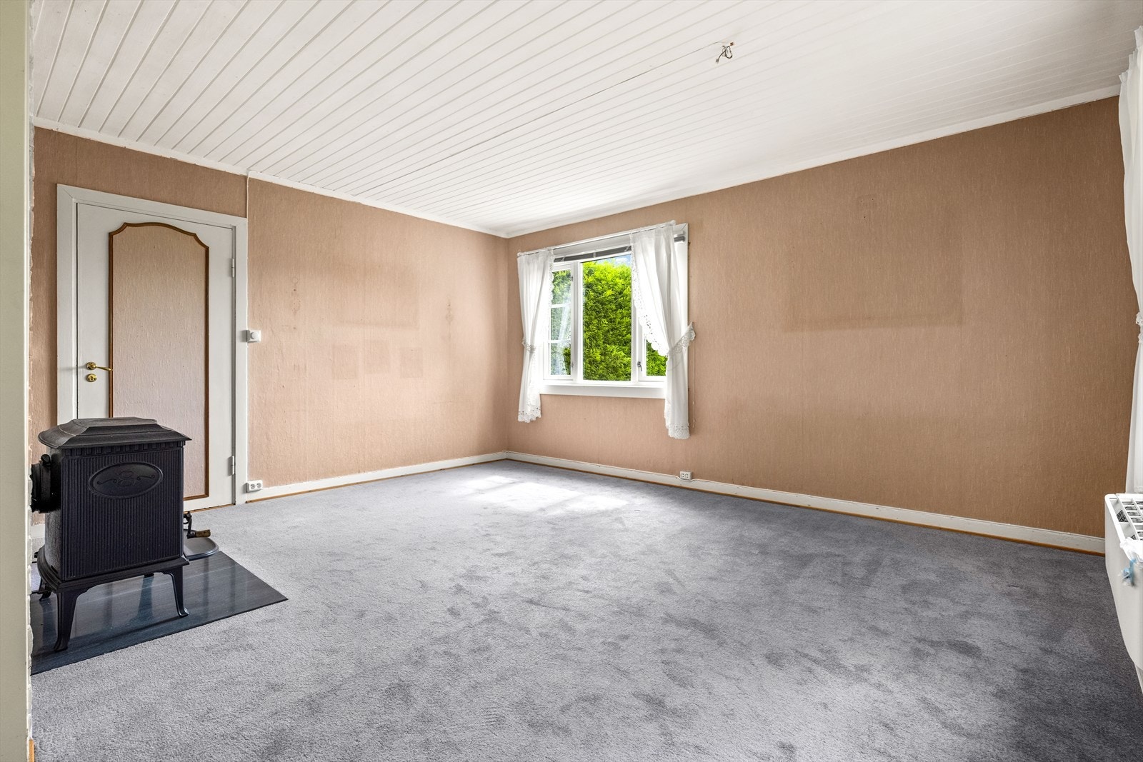Stuen er utstyrt med en vedovn tilknyttet en mursteinspipe med nytt røykrør. Galleribilde