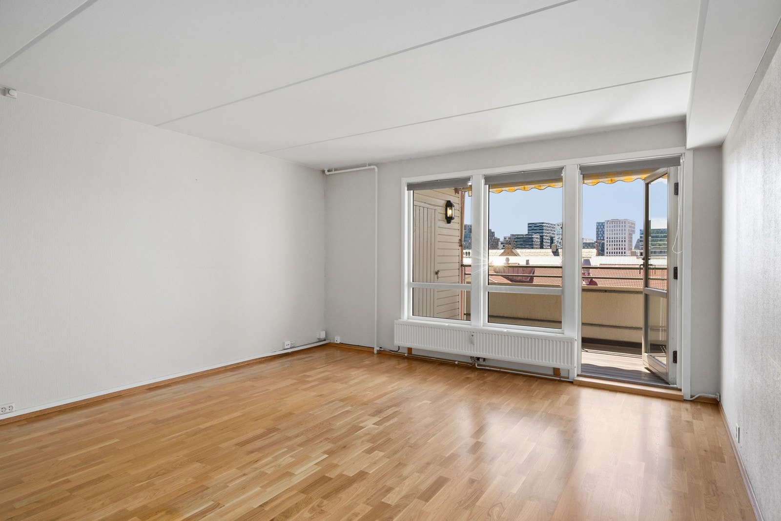 Lys og åpen stue med utgang til solrik balkong. Galleribilde