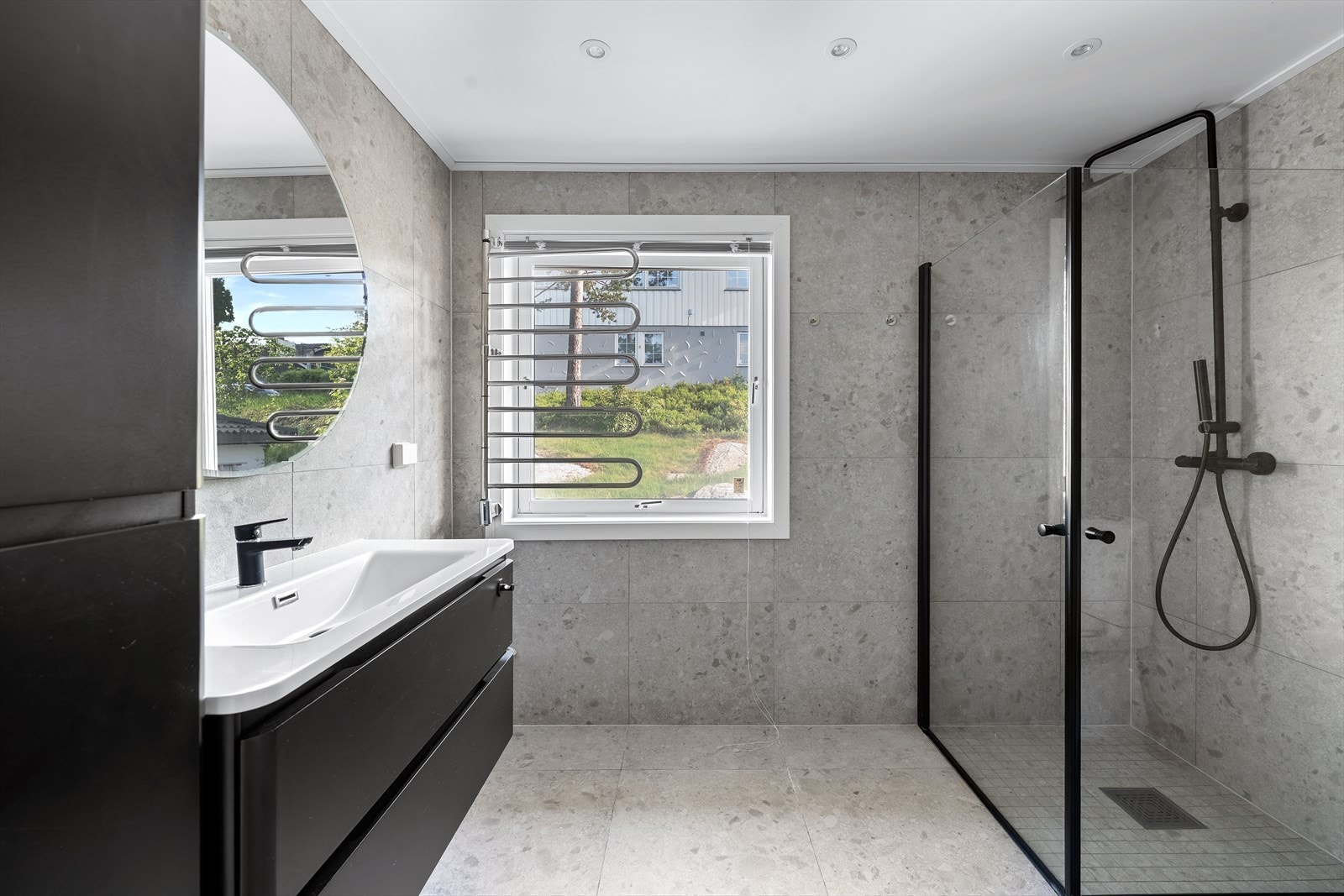 Lekkert og delikat bad med terrazzo fliser på gulv og vegger, med underliggende varmekabler i gulv. Badet er innredet med servantskap med servant og ettgreps armatur, speil samt toalett. Galleribilde