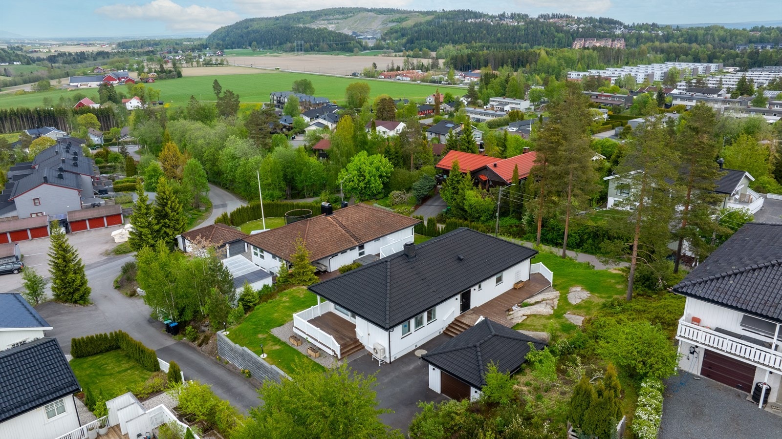 Eiendommen har en pent opparbeidet tomt med asfaltert gårdsplass, beplantning og hage med "fjell i dagen". Det er parkering i garasje, samt på egen gårdsplass Galleribilde