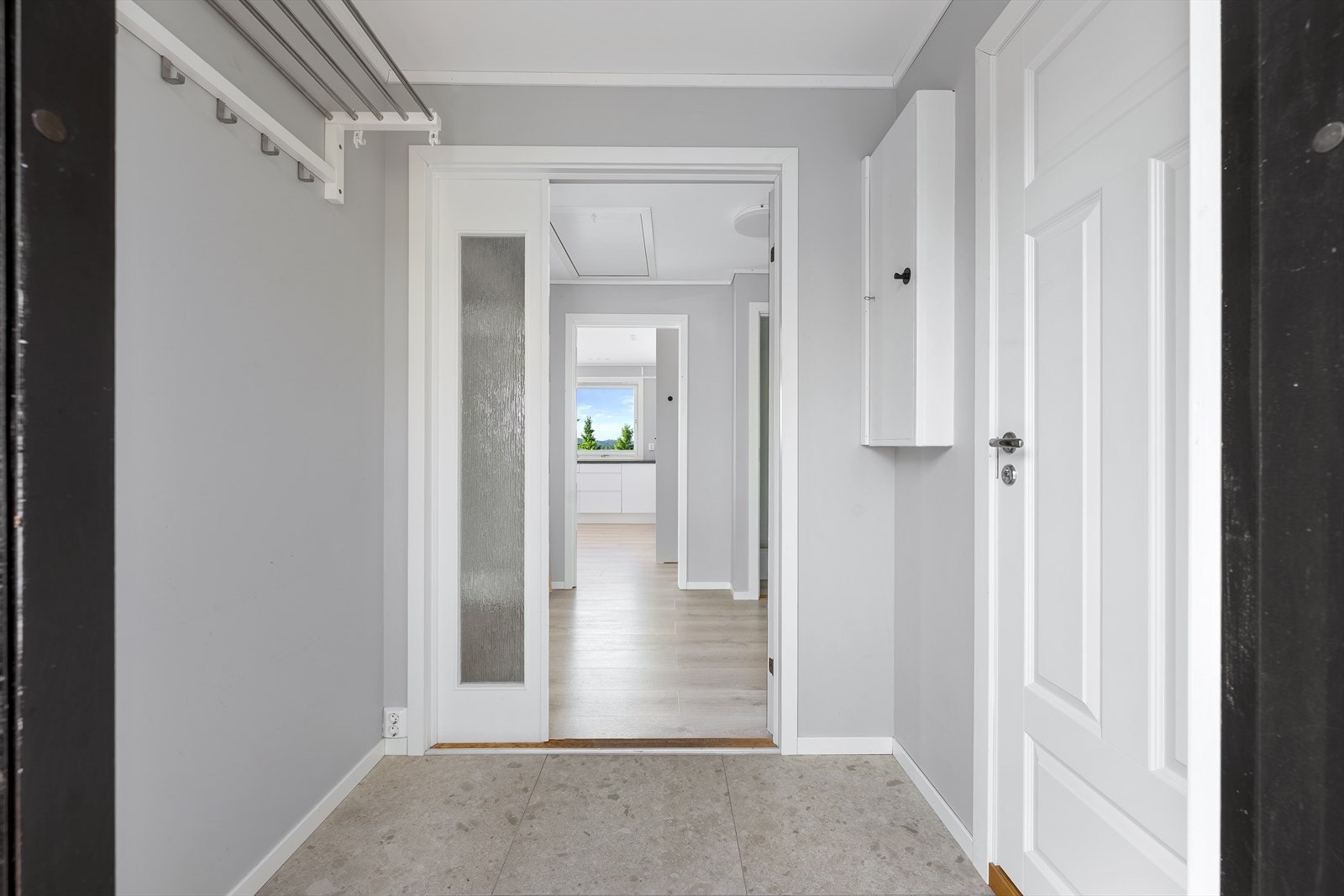 Velkommen inn! Entreen er pent innredet med terazzano fliser på gulv, med underliggende varme i gulv, og fin plass for knaggrekke Galleribilde
