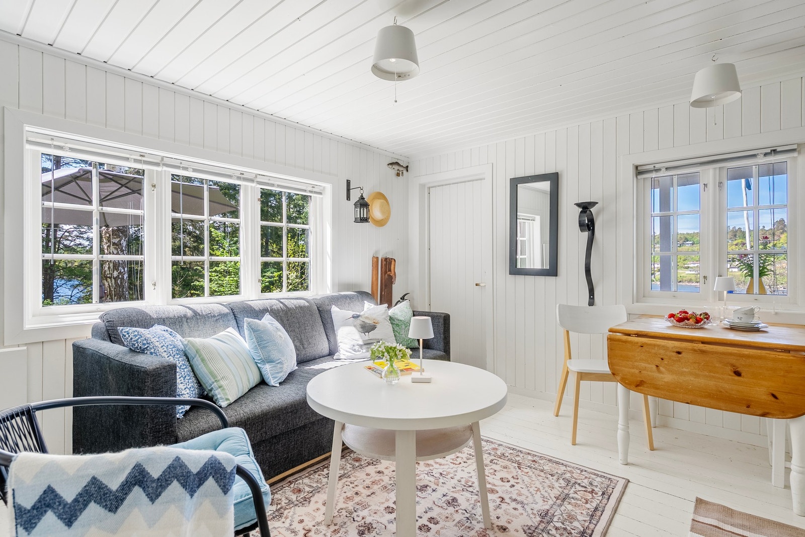 Sjøutsikt fra flere steder i stuen og god plass til både sofahygge og et mindre spisebord Galleribilde