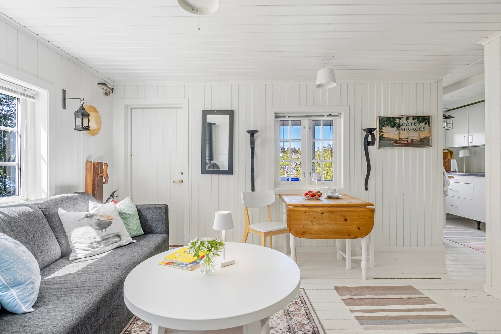 Lys og koselig stue med store vinduer som slipper naturen og landskapet inn og gir et flott lysinnslipp Galleribilde