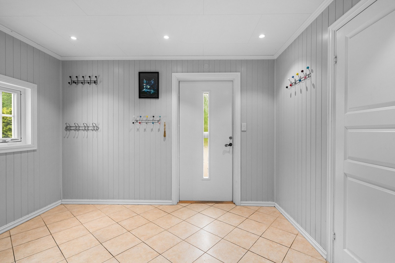 Inngangspartiet gir et ryddig og funksjonelt førsteinntrykk med flislagt gulv, panelte vegger og downlights i himling. Galleribilde