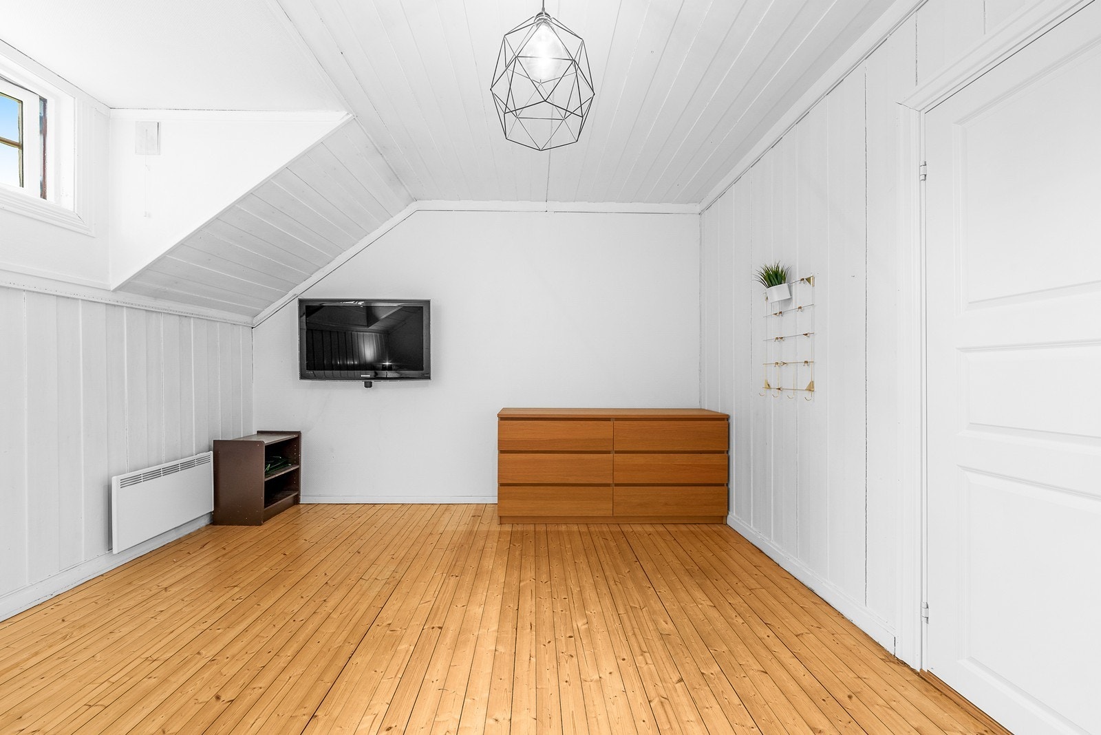 Innredet rom i etasjen med panel på veggene og originale tregulv. Galleribilde