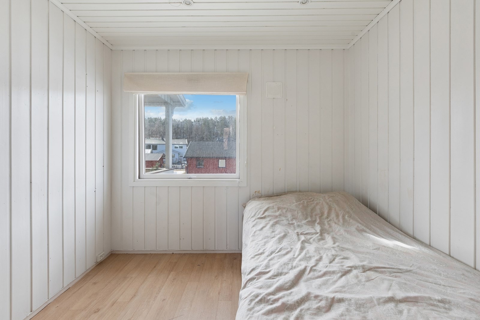 Første etasje inneholder to soverom. Dette rommet har lyse panelvegger. Galleribilde