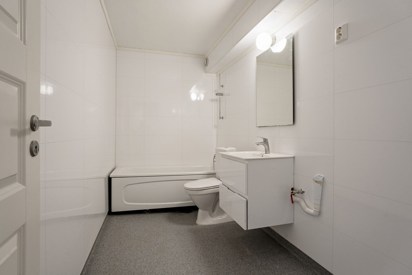 Badet er romslig og har blant annet badekar, opplegg for vaskemaskin og nyere overflater Galleribilde