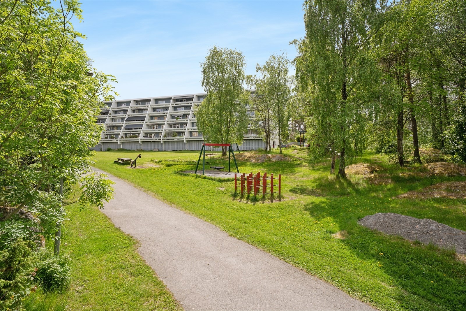 Grønne og frodige omgivelser rundt bygningene med plen og beplantning lett tilgjengelig for beboerne. Galleribilde