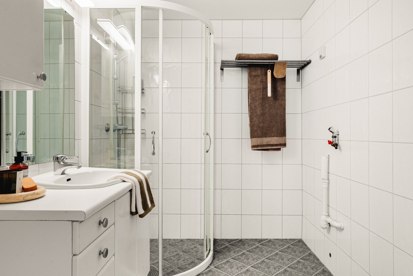 Badet inneholder ellers wc, dusjhjørne med glassdører og servantskap med speil. Galleribilde