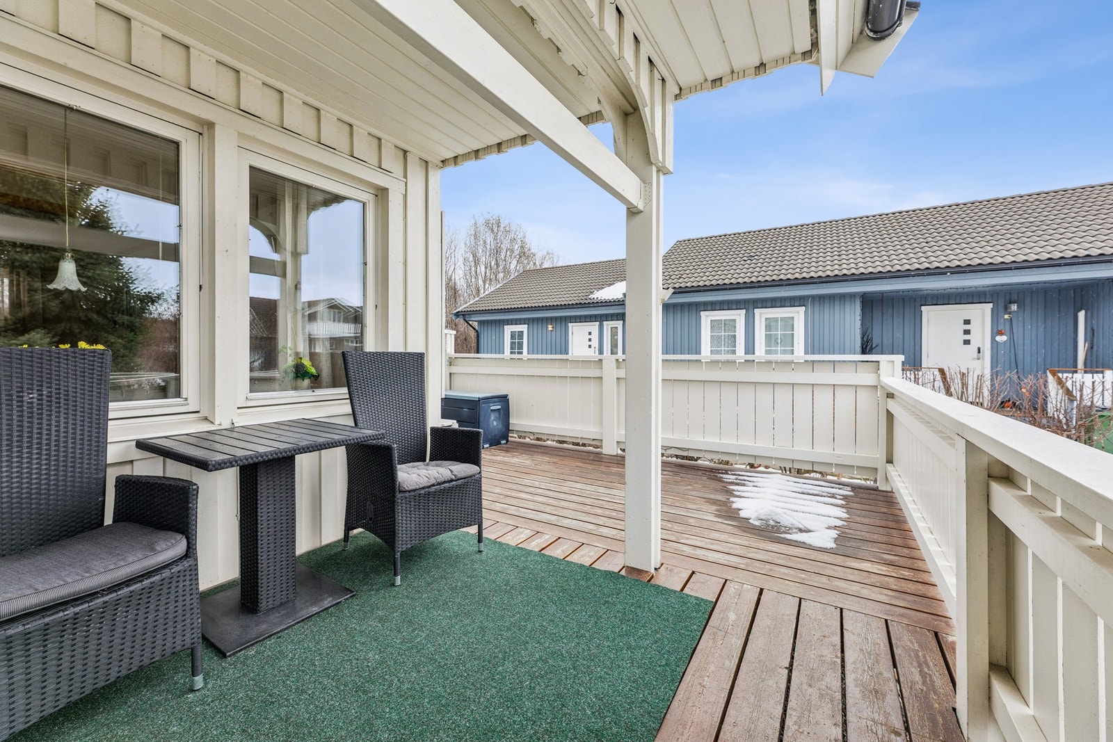 Overbygget veranda med plass til en liten sittegruppe. Galleribilde