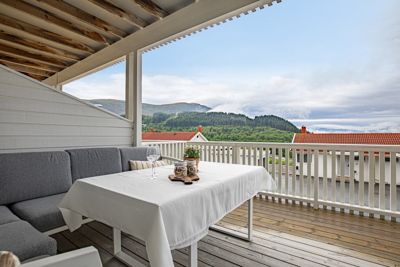 På sørsiden har leiligheten stor, delvis overbygget terrasse (over garasjer) på hele 28 m² med tilkomst fra stua | terrassen fikk nytt terrassedekke i 2022 Galleribilde