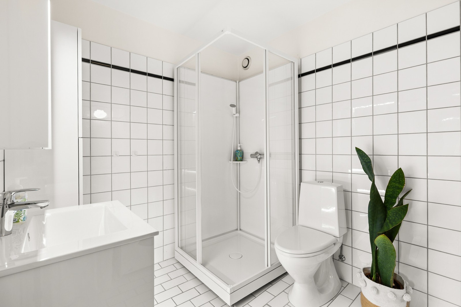 Badet er flislagt og ble oppgradert i 2018 med nytt dusjkabinett, varmtvannsbereder, toalett og baderomsmøbler Galleribilde