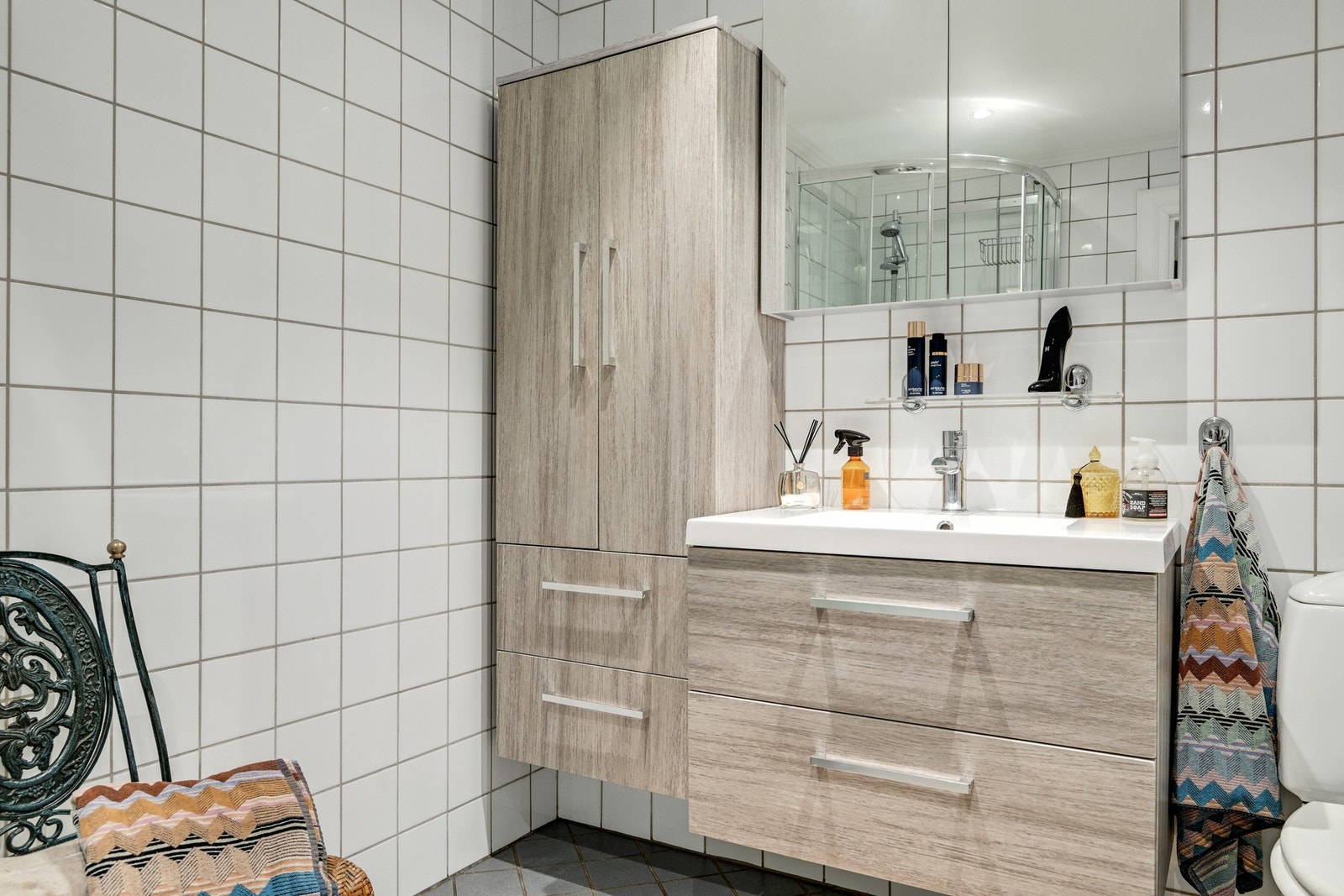 Badet er innredet med klosett, dusjkabinett og pen baderomsinnredning med speilskap Galleribilde