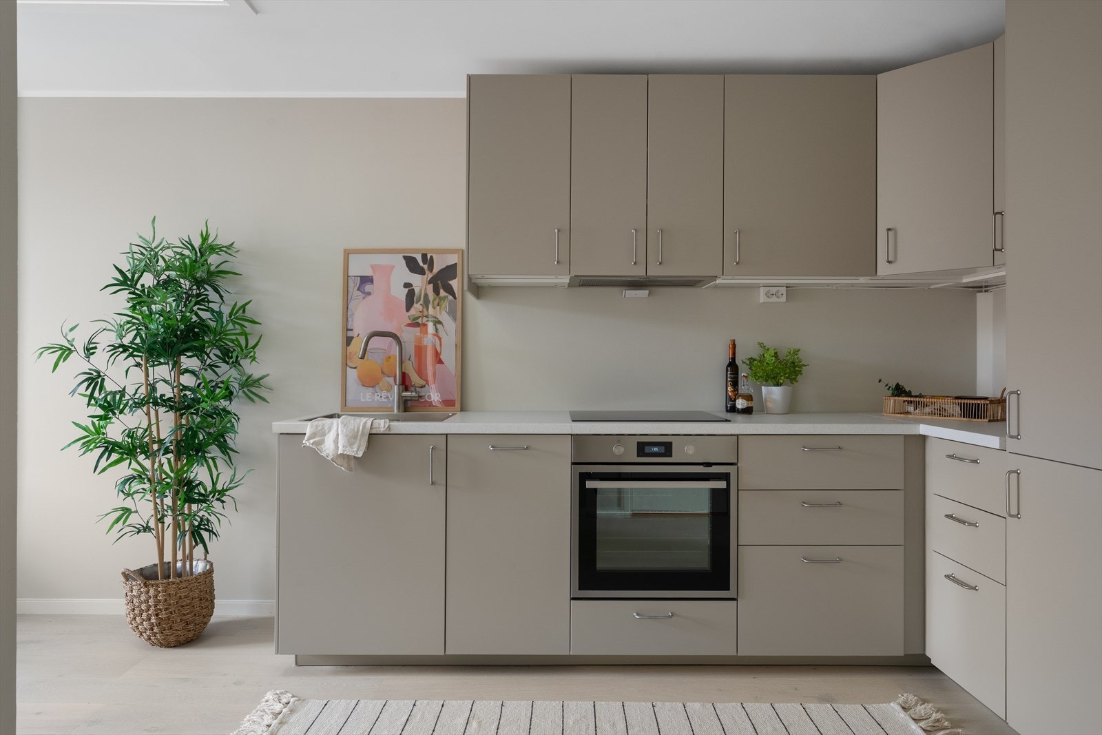 Stilrent IKEA-kjøkken med glatte fronter, laminatbenkeplate og integrerte hvitevarer. Galleribilde