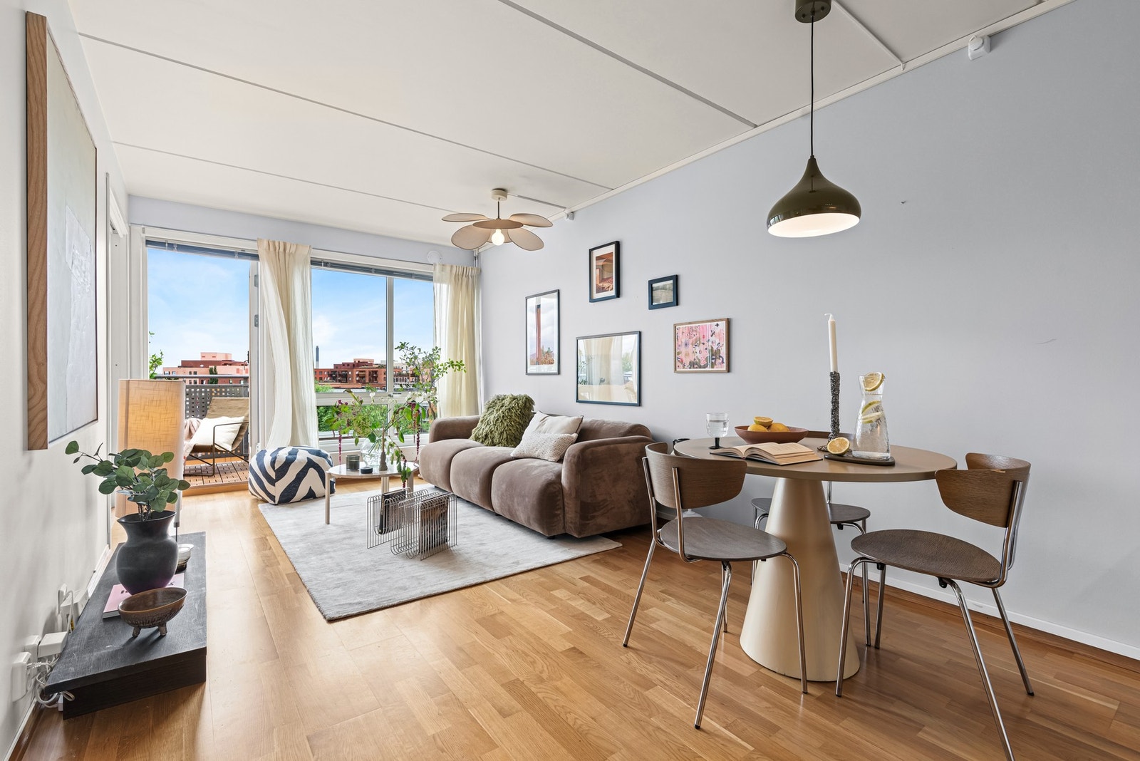 Store vinduer i enden av rommet fyller innsiden med dagslys, og det er utgang til balkong Galleribilde