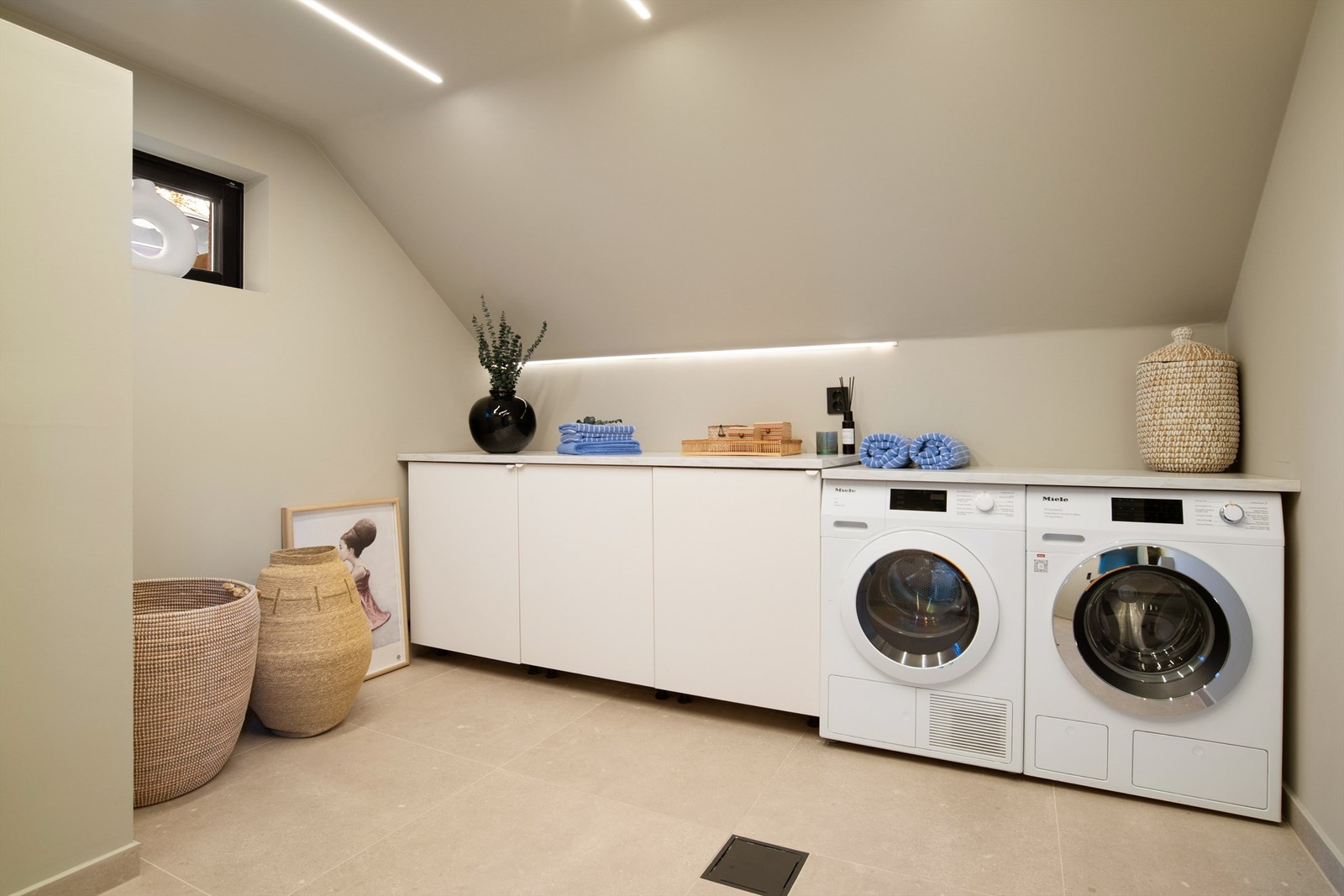 Flott vaskerom med plass til både vaskemaskin og tørketrommel. Rommet er innredet med vaskeromsinnredning med god plass til vaskeutstyr, strykejern o.l. i skap. Det er opplegg til vask i rommet Galleribilde