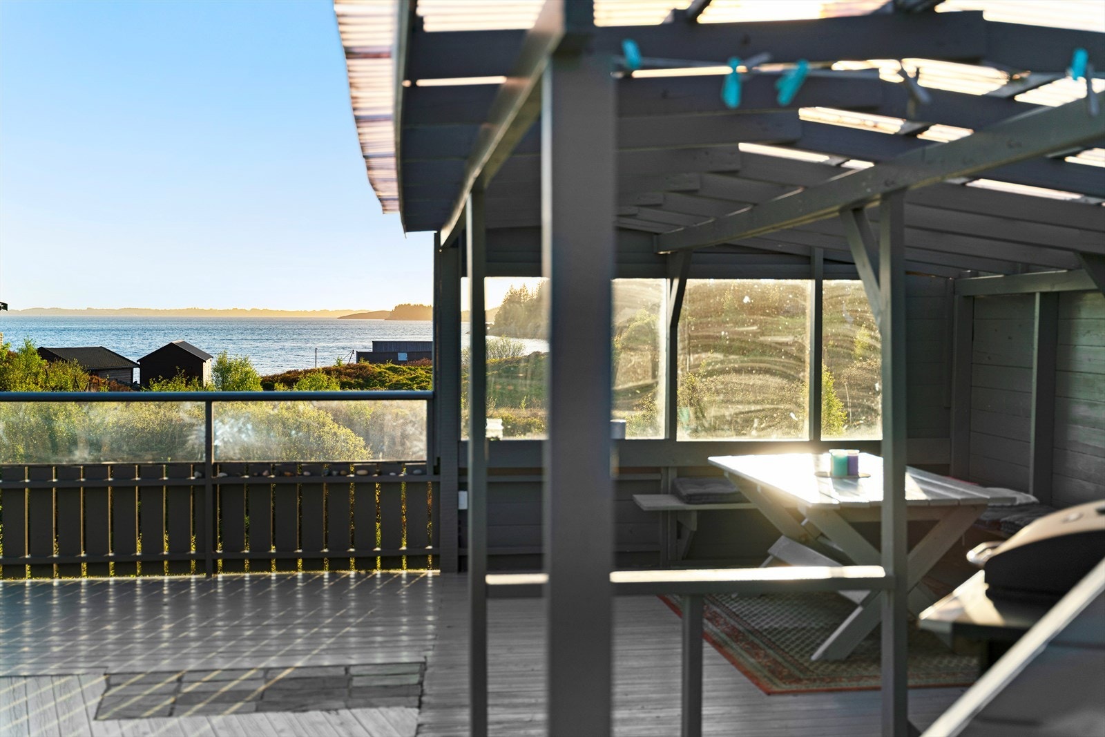 Lite overbygg på terrassen med flott utsikt mot sjø og ned mot nausteområdet. Galleribilde