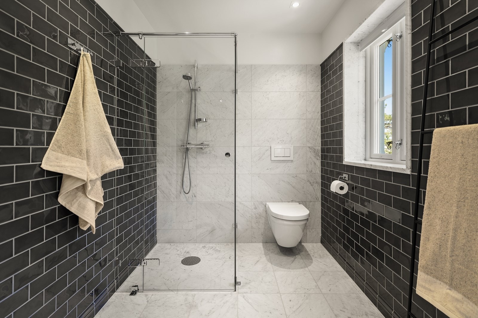 Dette badet er utstyrt med et romslig dusjhjørne og vegghengt toalett. Galleribilde