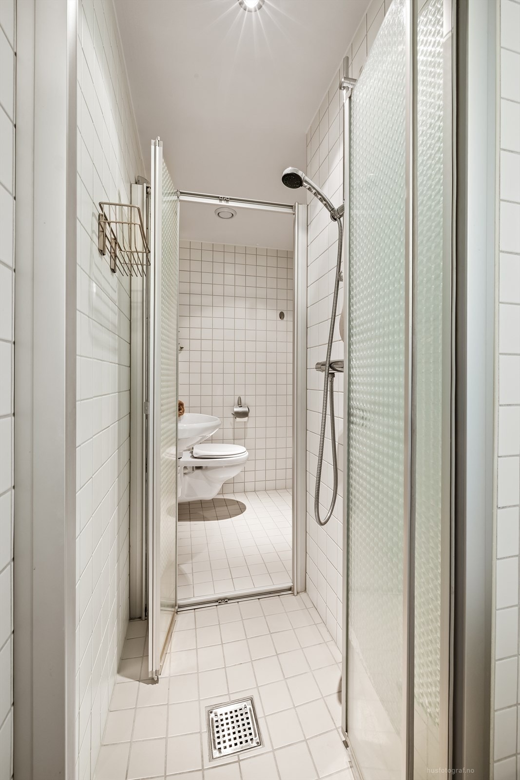 Badet har flislagte overflater, varmekabler i gulvet og en praktisk dusjnisje. Galleribilde