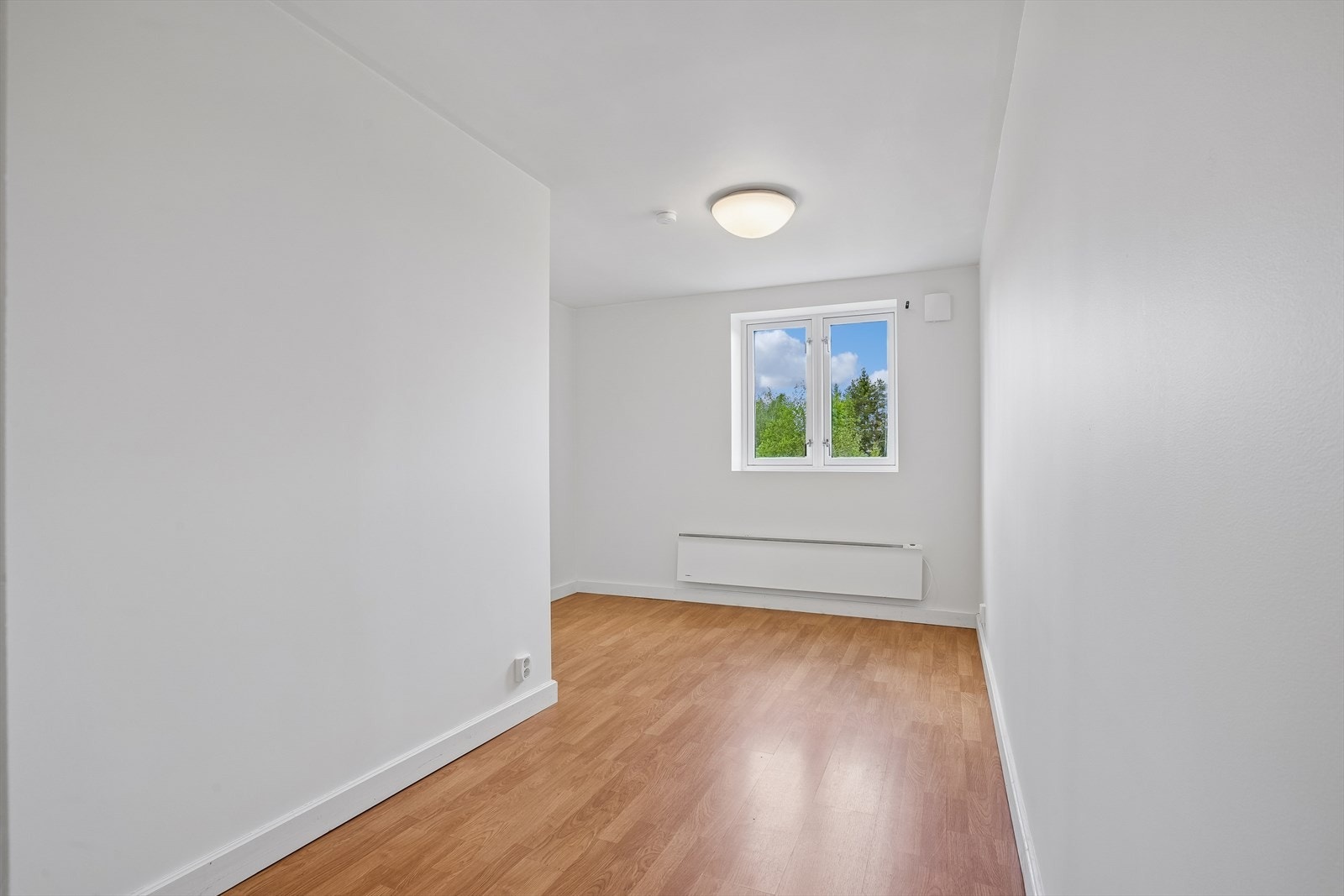 Et lyst og anvendelig rom med malte, slette vegger og laminatgulv. Galleribilde