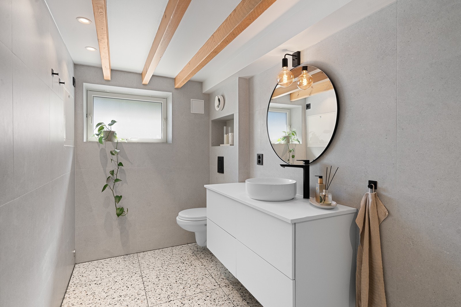 Badet er nytt og lekkert, med terrazzo-fliser, varmekabler i gulv og downlights i taket. Galleribilde
