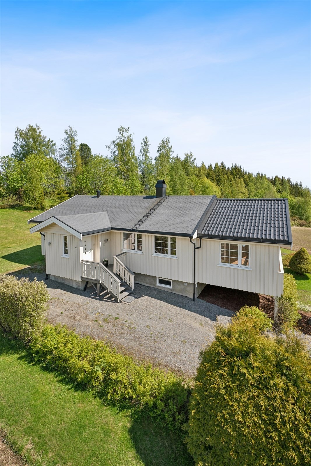 Boligen har en gruset gårdsplass med adkomst til både hovedinngang og kjellerinngang. Galleribilde