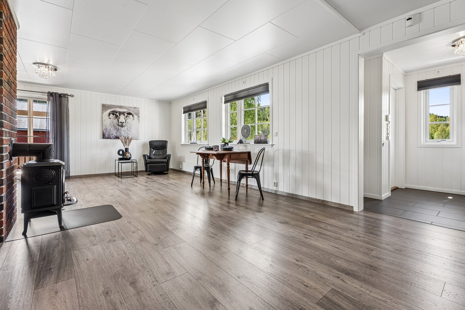 Stuen er romslig med plass til både spisebord og sofagruppe. Vedovnen gir ekstra varme og hygge. Galleribilde