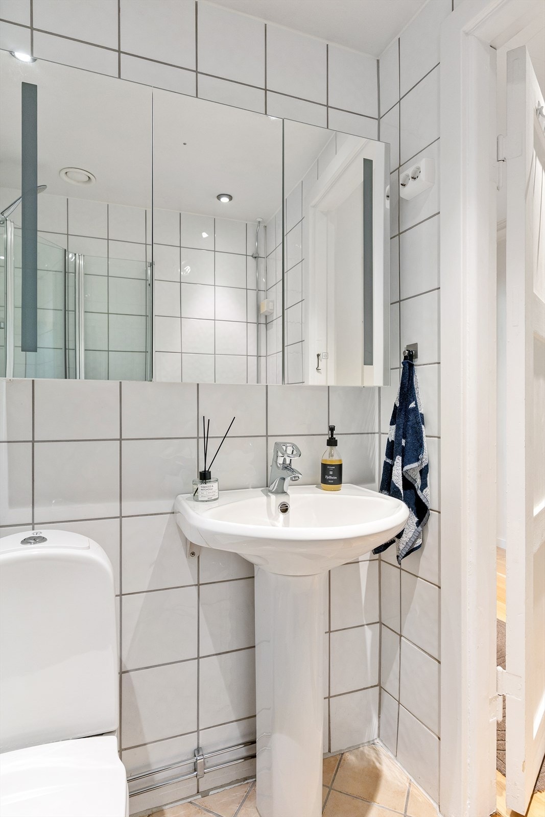 Badet er innredet med klosett, servant og speilskap med lys. Galleribilde