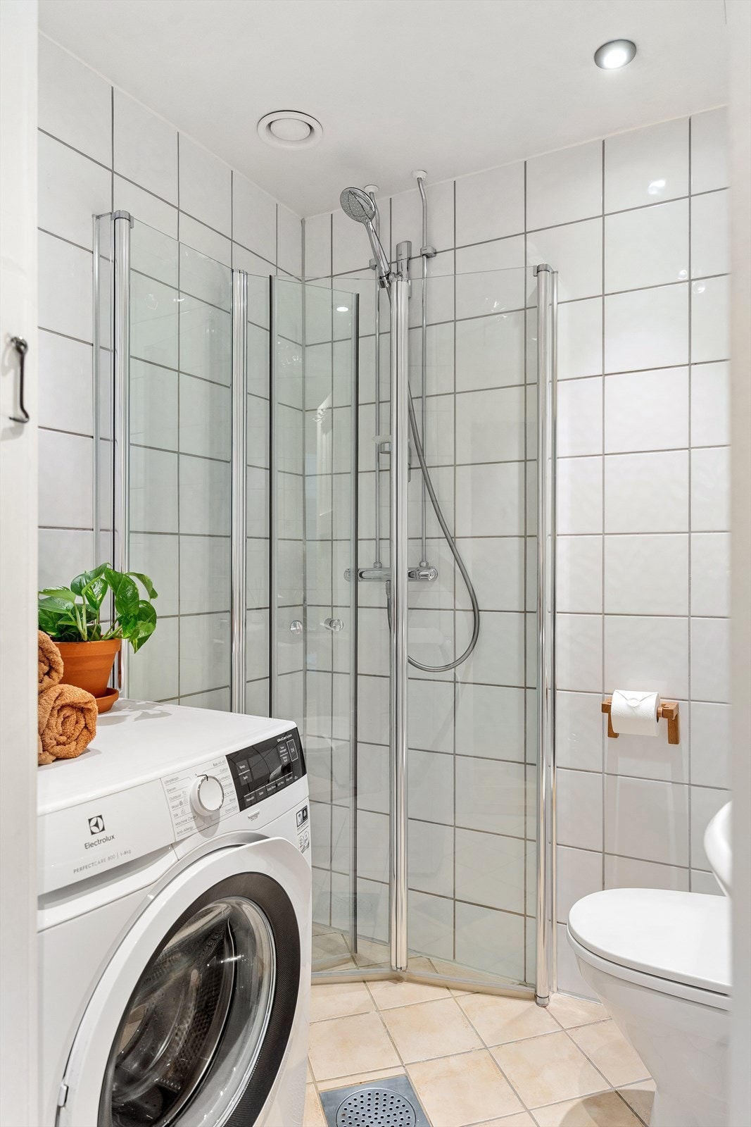 Badet har dusjhjørne med svingbare glassdører og opplegg for vaskemaskin. Galleribilde
