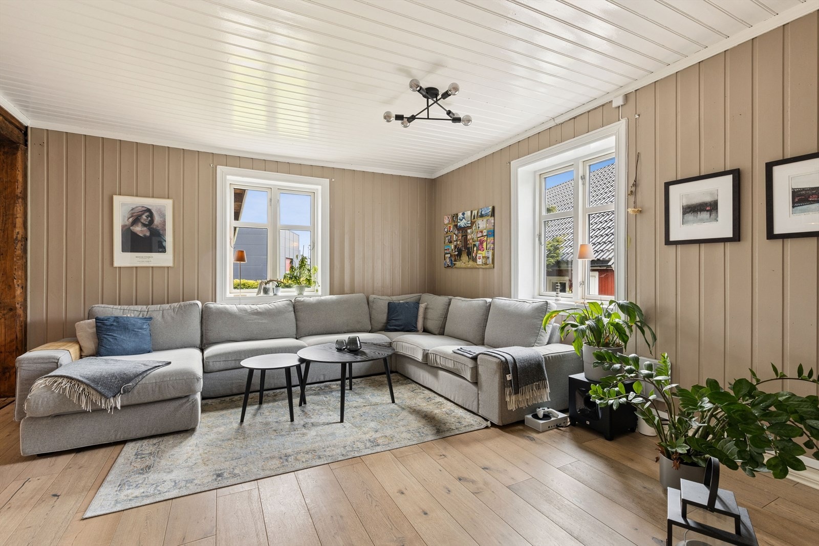 Rommet har parkett på gulvet, vegger med trepanel og synlige tømmerdetaljer som understreker boligens karakter. Galleribilde