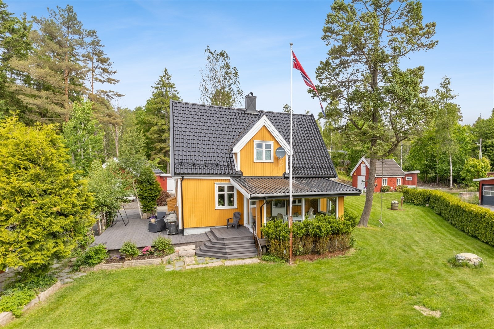 Tomten er opparbeidet med hage og rikelig med parkeringsareal, og ligger i et lett skrånende terreng. Galleribilde
