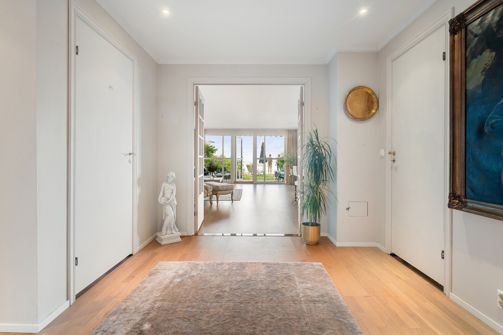 Gangen er smakfullt innredet med parkett på gulv, downlights belysning og adkomst til romslig garderoberom hvor man kan henge fra seg yttertøyet. Galleribilde