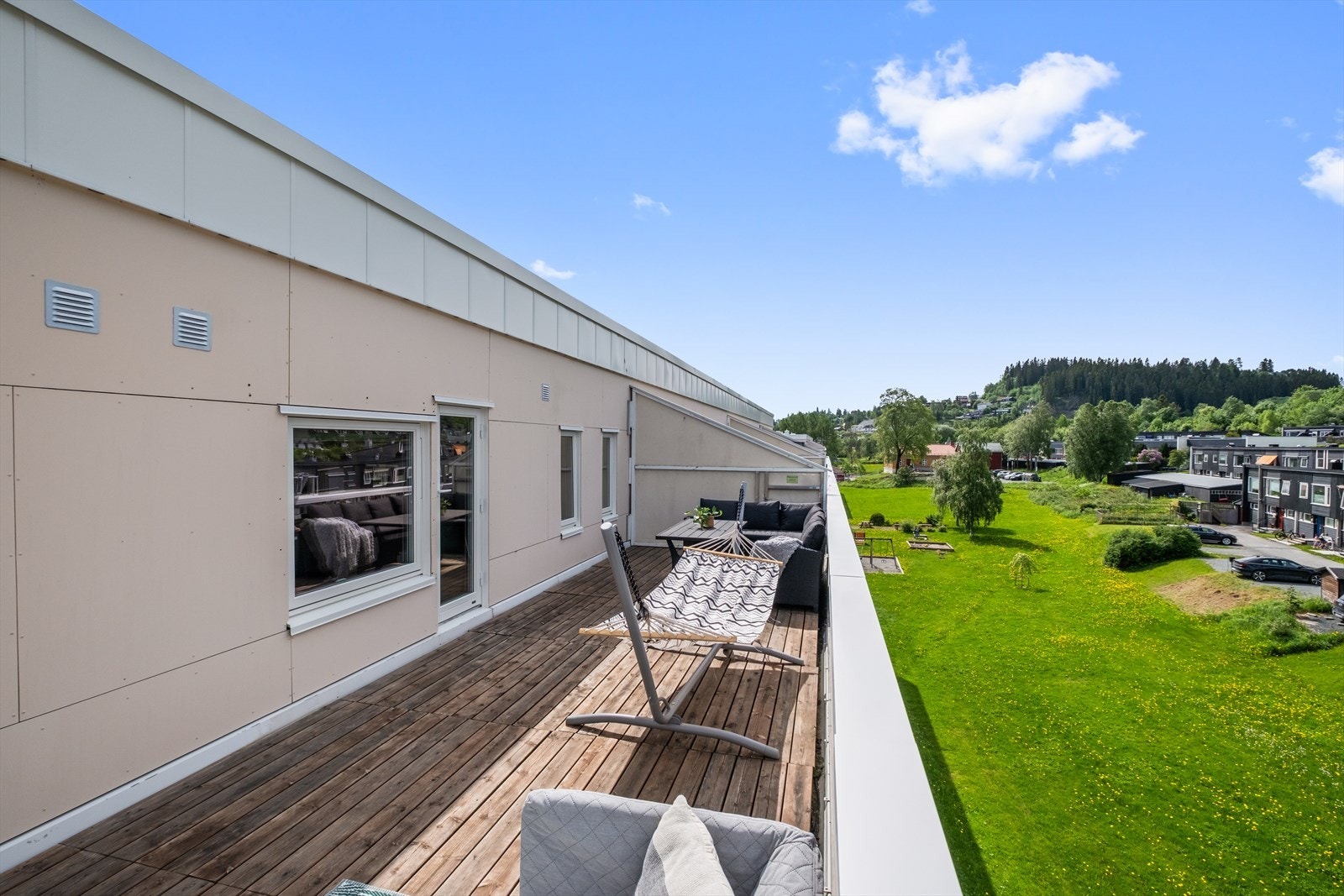 Stor og moderne terrasse som utvider leilighetens oppholdsareal og skaper en sømløs overgang mellom inne- og uteområde. Galleribilde