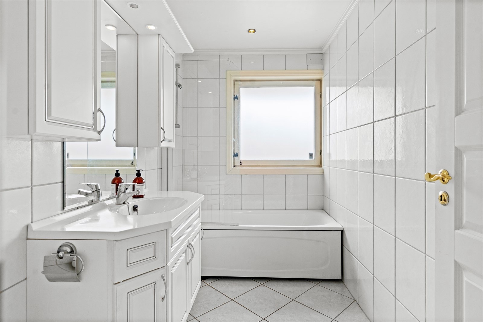 Badene ligger vegg i vegg, innredet med hvite vegg- og gulvfliser. Varme er lagt i gulvet, og begge badene har toalett og downlights. På det største badet er det et badekar med dusjvegg. Galleribilde