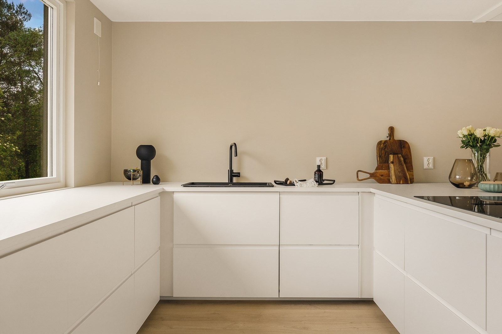 Flott IKEA-kjøkken fra 2025 med slette fronter, laminat benkeplate og stålvask, samt rikelig med skap- og benkeplass Galleribilde